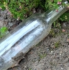 Glass bottle litter in dirt